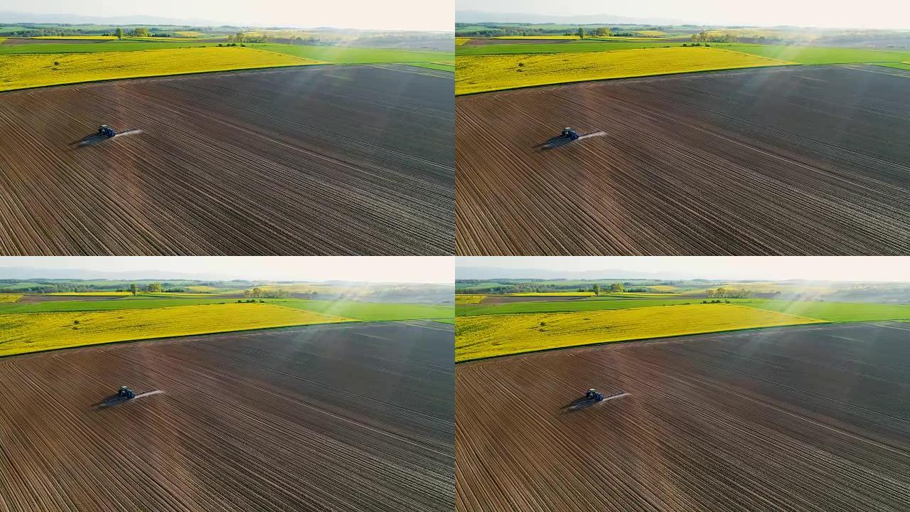 农业。农用拖拉机喷涂场的无人机视图。