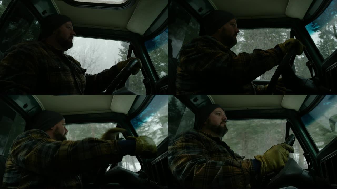 一个三十多岁的白种人留着胡须，在一个下雪的冬天，他在常绿的森林里开着卡车。