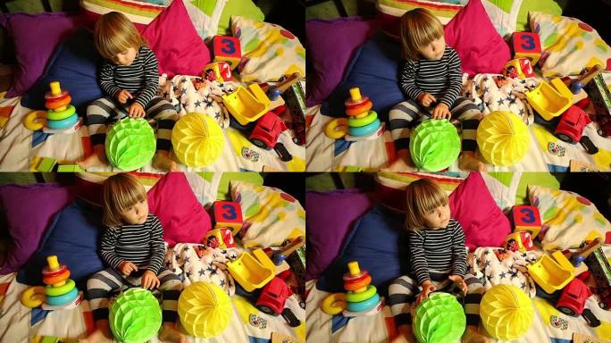 沉思的小孩正在玩不同形状的玩具