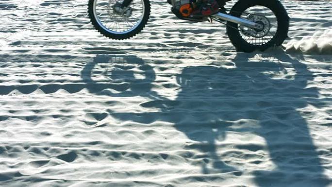 摩托车穿越沙子的阴影，慢动作