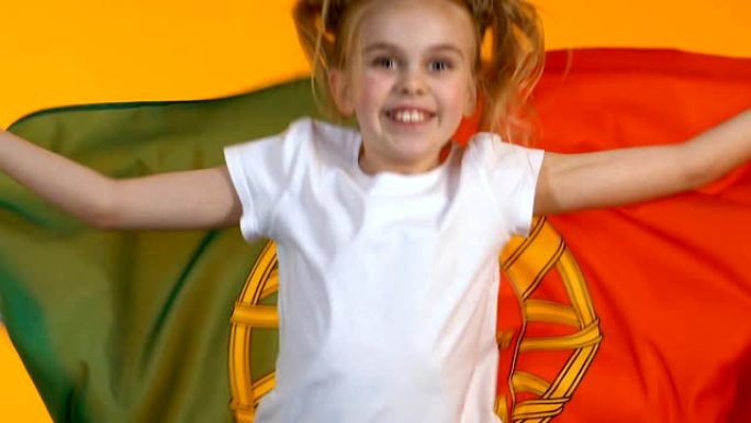小女孩挥舞着葡萄牙小球迷的旗帜为国家队加油