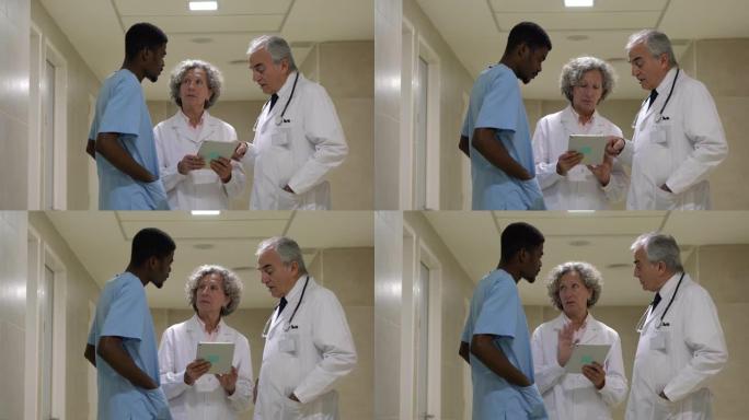 医生和黑人外科医生团队在查看平板电脑上的病历时讨论了一个病例