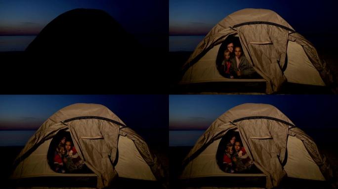 难民家庭坐在帐篷里，躲避岸边的移民边境服务
