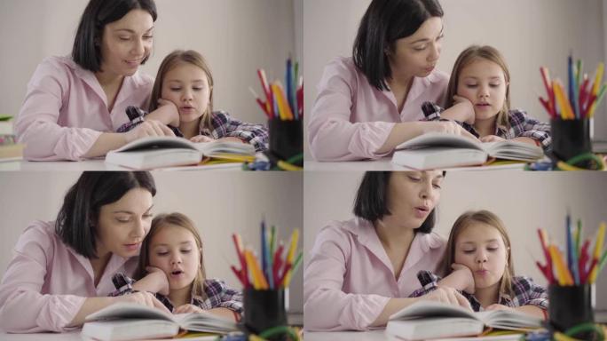 可爱的高加索女孩在家和妈妈一起看书的特写。快乐的女学生和父母一起做作业。母亲帮助女儿学习。智力、教育