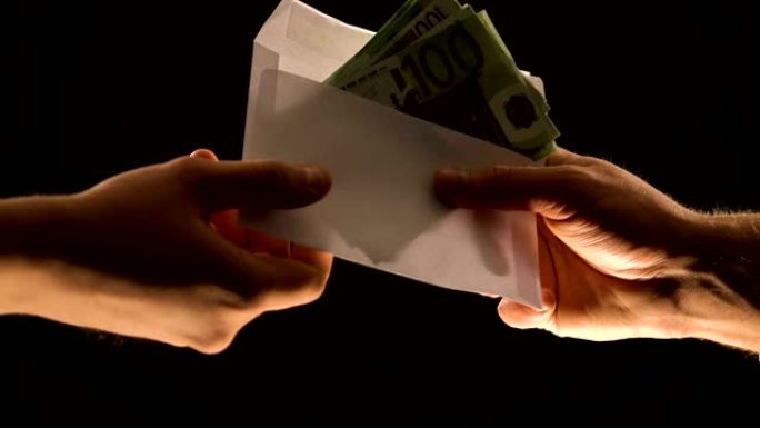 手给欧元在信封孤立黑色，腐败或非法工资