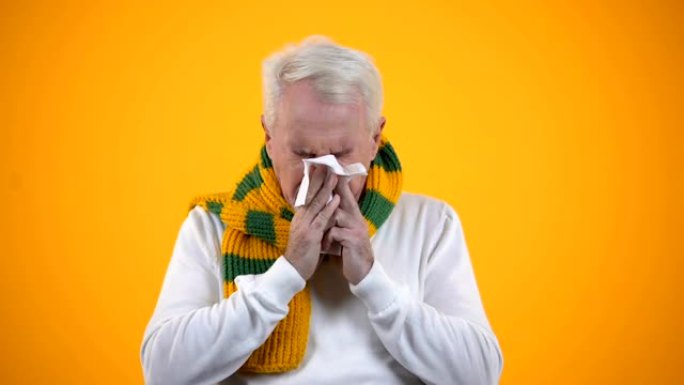 老年男性在围巾吹鼻子组织，大黄或鼻炎，流感症状