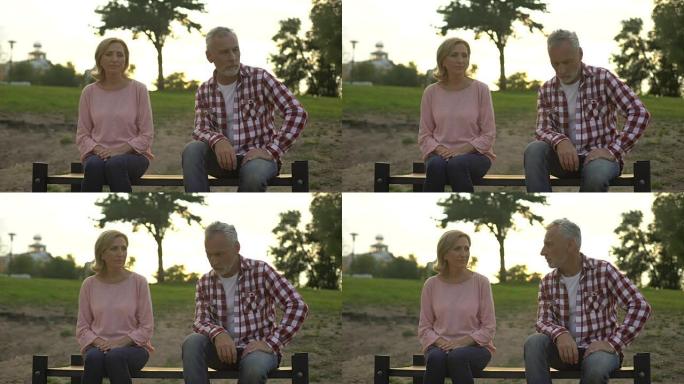 关系危机，退休男女坐在公园的长凳上，吵架