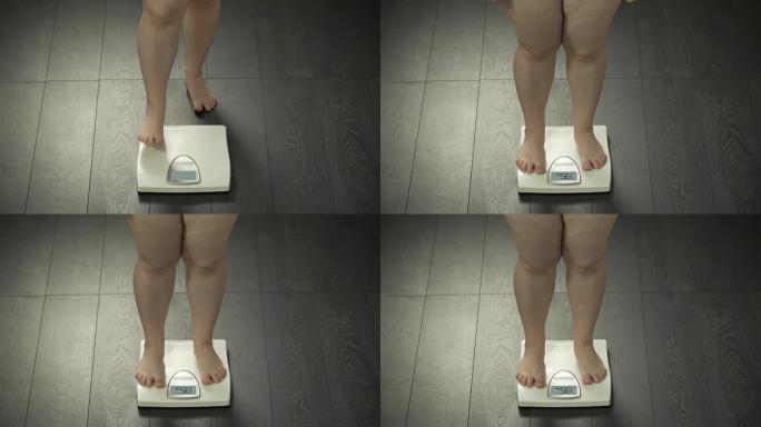 女人的腿踩在家里的秤上，正常体重，成功的饮食结果
