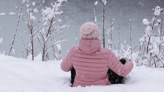 女人看着雪花落在白雪皑皑的森林里