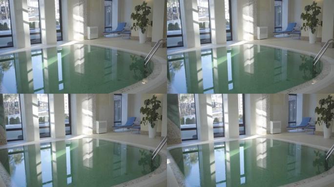 早晨阳光下豪华酒店的小游泳池。碧绿的水在阳光中闪闪发光。旅游、休闲、豪华。