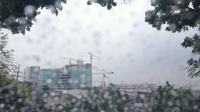 4K: 窗玻璃上的雨滴，背景中的建筑工地