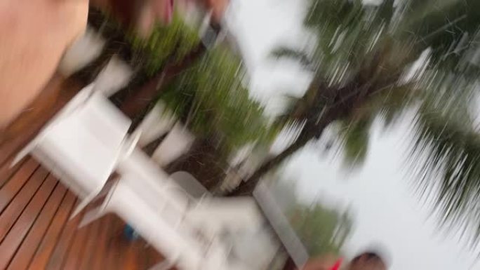 朋友在海边的房子里在雨中踢足球时拍摄/做视频聊天