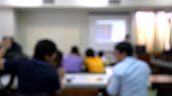 抽象模糊人们在教室里用笔记本学习、演讲、开会或做研讨会