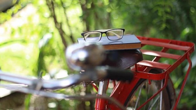 从自行车鞍座上拿书和眼镜