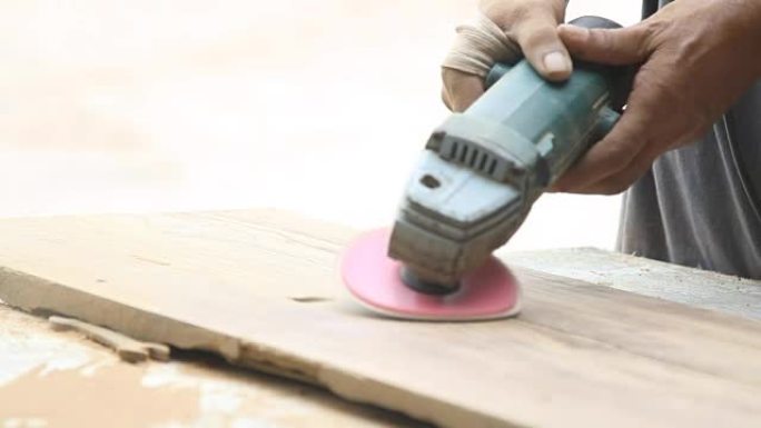 木匠在木头上使用砂光机