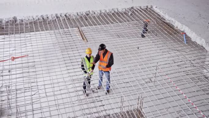 LD男建筑师站在建筑工地与一名女工交谈