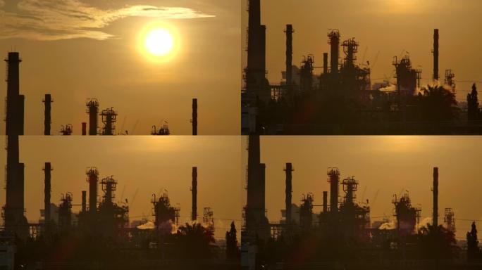 4K分辨率炼油厂在清晨日出时用反射剪影结构的烟囱释放烟气