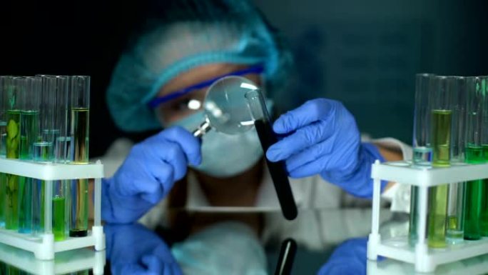科学家用放大镜在试管中观察黑色物质，进行检查