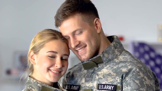 快乐的年轻军人和女人看着相机，军人夫妇，美国军队
