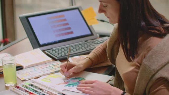 年轻的平面设计师在现代台式计算机上工作，同时在办公室的办公桌上使用图形平板电脑