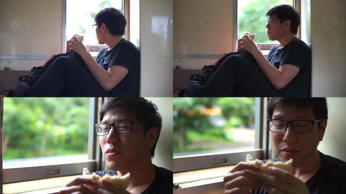 亚洲男子在当地火车上旅行时吃中国面包