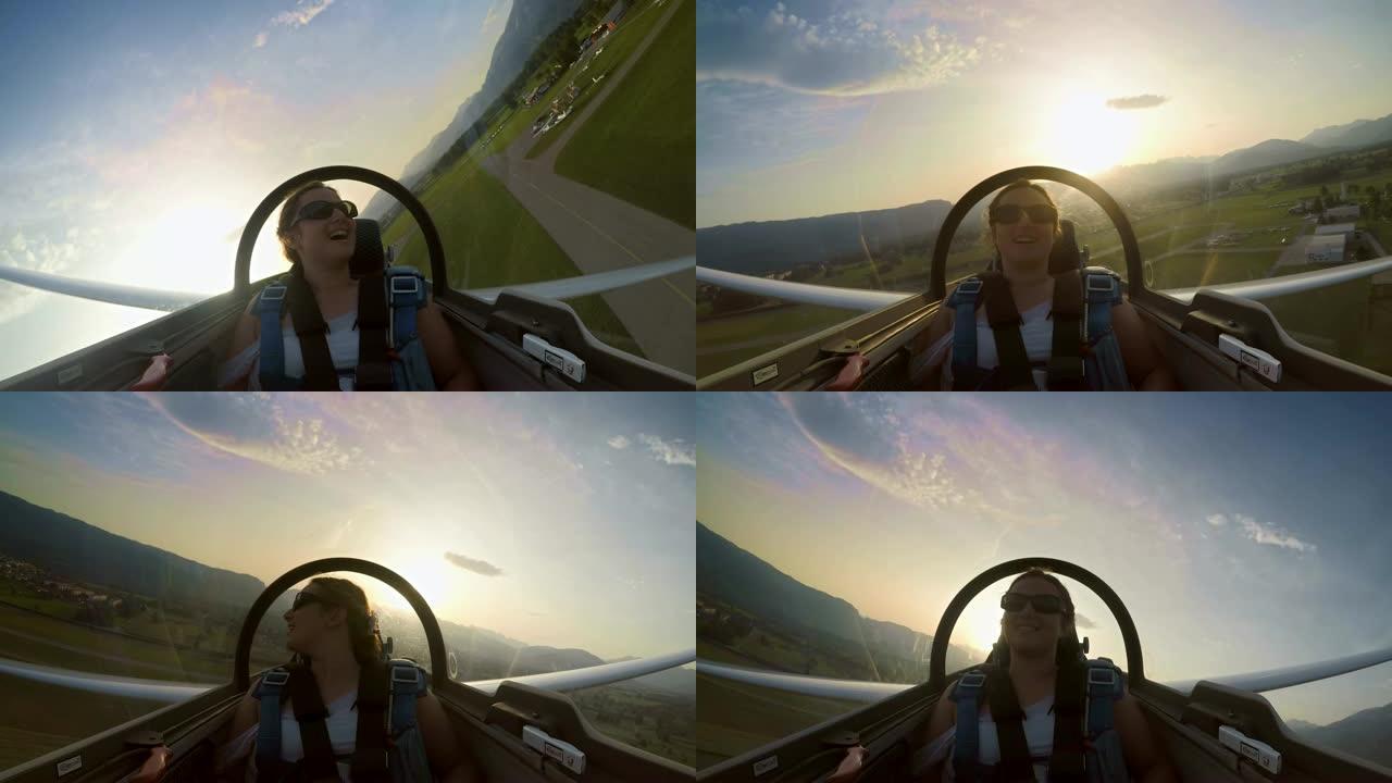 滑翔机乘客座位上的LD年轻女子在日落时享受飞机低空滑行