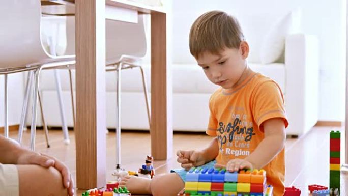 用塑料砖整理房子时，小男孩拍手