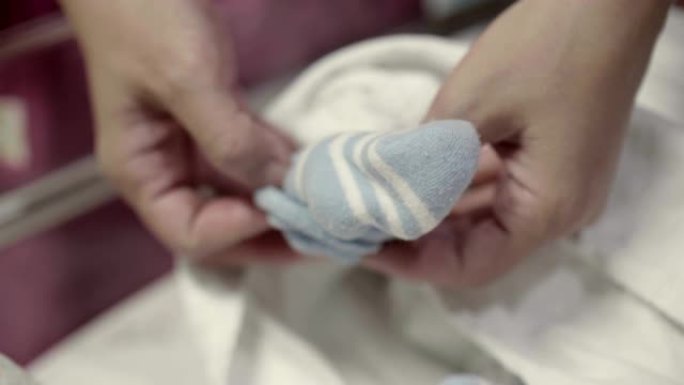 年轻的母亲给男婴穿衣服 (0-1个月)
