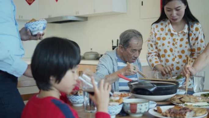 女人在春节的家庭用餐中向丈夫提供食物