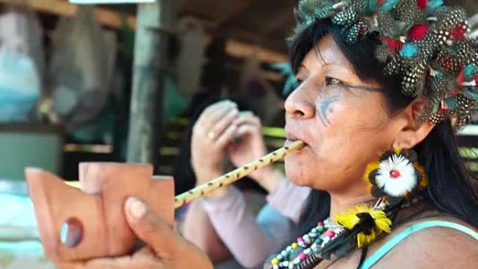 来自瓜拉尼族的巴西土著妇女吸烟烟斗