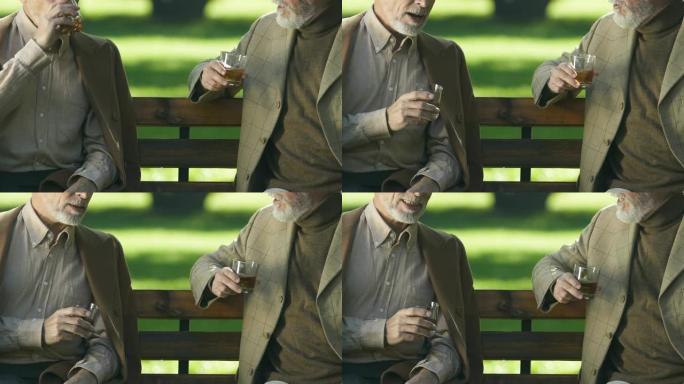 年老的成功商人享受精英威士忌口味，坐在外面休息