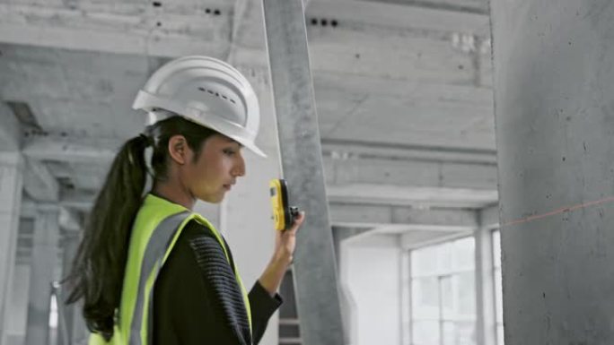 女建筑师测量工业建筑中的支撑梁并对其进行标记