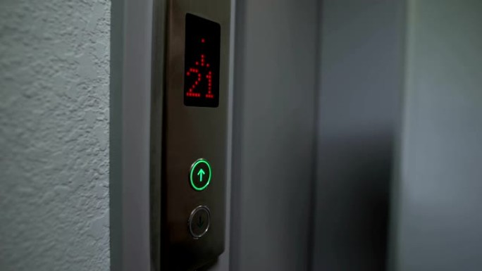 手指按下电梯按钮到楼上，电子液晶显示器，特写