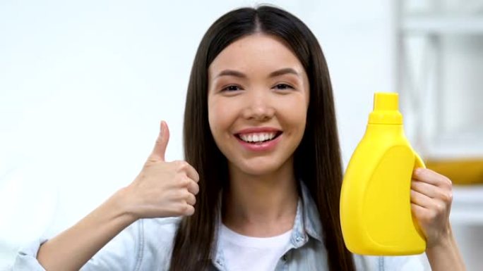 微笑的家庭主妇拿着水洗凝胶，竖起大拇指，顾客评论