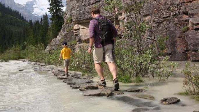 父亲和儿子沿着小溪走垫脚石