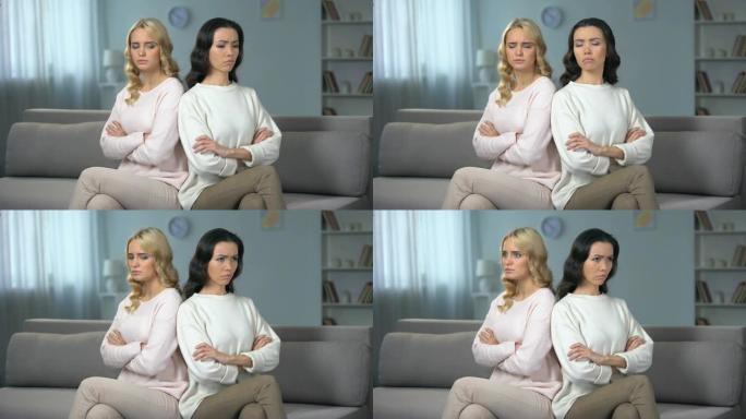 两个愤怒的女人坐在沙发上吵架，朋友之间发生冲突
