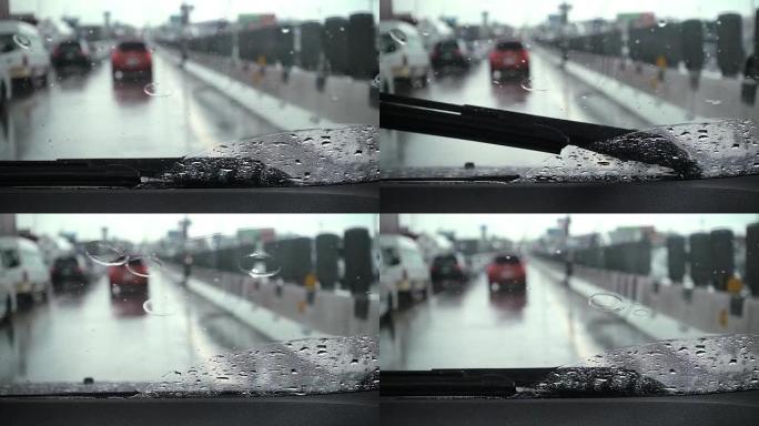 汽车雨刮器正在缓慢清除雨水并在道路上行驶