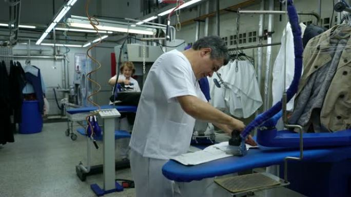 拉丁美洲的成年雇员在工业洗衣服务熨烫衣服