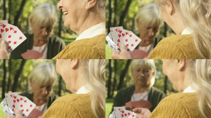 微笑的高级女人在外面和朋友打牌，退休空闲时间