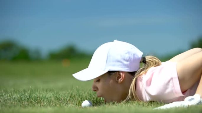 有趣的女性高尔夫球员吹球洞，成功的策略和狡猾