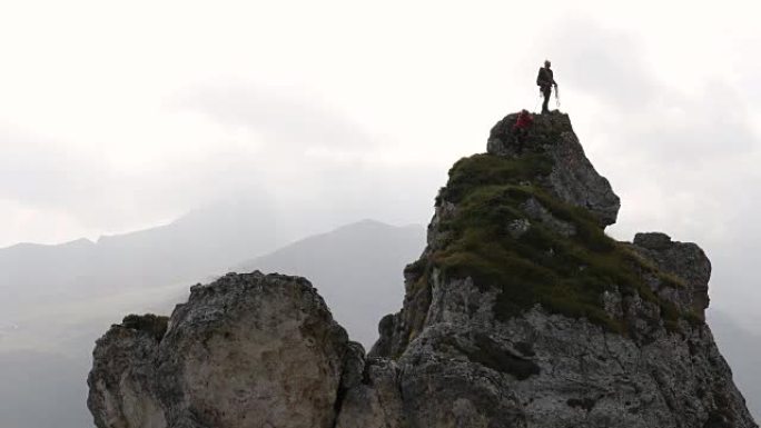 登山者登上深谷上方的岩石顶峰