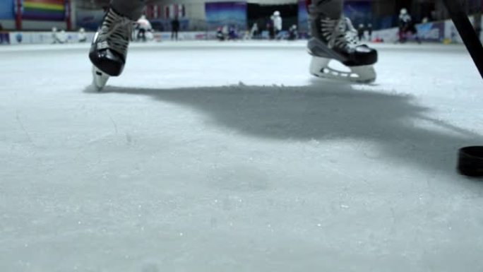 4k慢动作特写冰球运动员正在练习使用曲棍球棒运球。冰球溜冰场