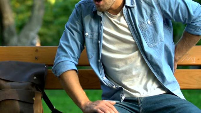 男性感觉突然背痛坐在公园的长凳上，神经痛，肾脏疾病