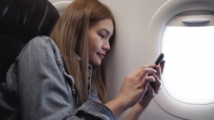 玩手机的飞机上的女人