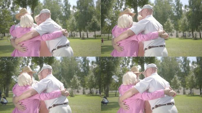两对可爱的成熟夫妇在公园里拥抱在一起，围成圆圈。