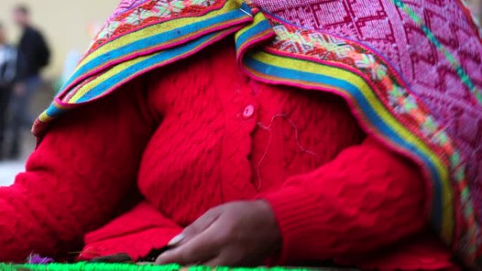 秘鲁妇女在Ollantaytambo编织彩色羊驼羊毛