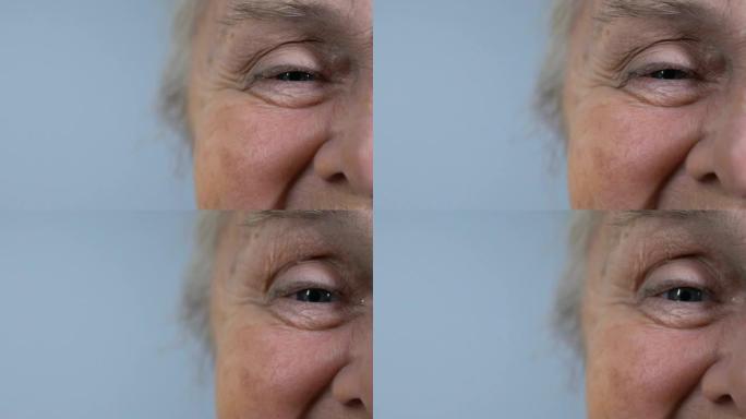 皱巴巴的老年女性看着相机，人口统计，半脸特写