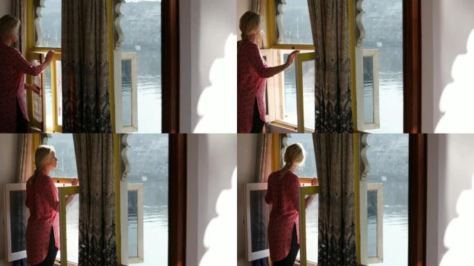 女人在日出时打开窗户，房间景观