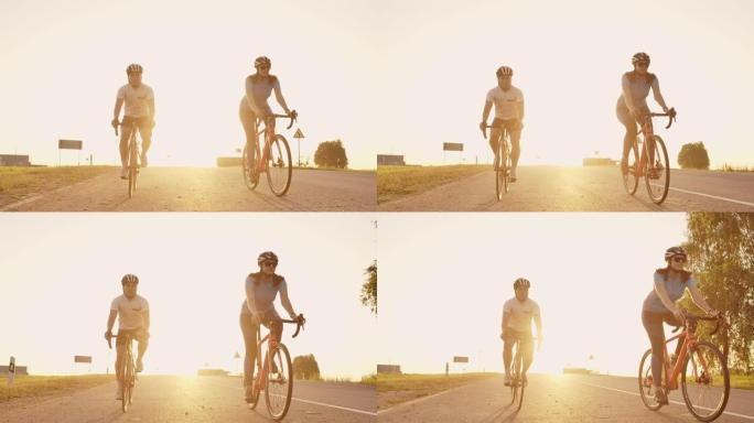 夕阳西下，一男一女骑着自行车在路上慢动作地骑行。这对夫妇骑自行车旅行。运动自行车头盔