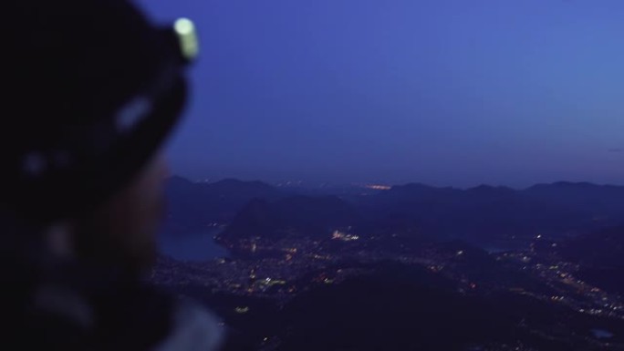 夜间徒步旅行者向遥远城市的特写镜头